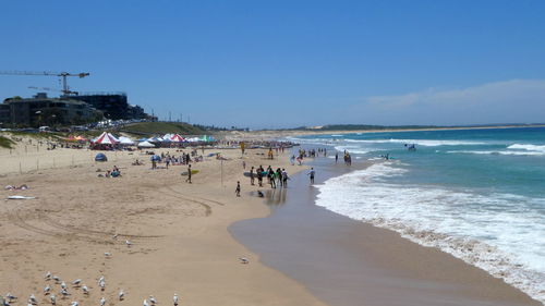 Panoramic view of people on beach against sky