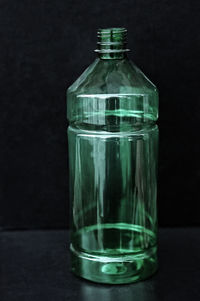 Close-up of empty plastic bottle against black background