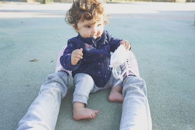 Full length of girl sitting outdoors