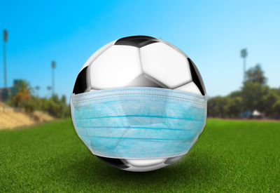 Close-up of blue ball on field by swimming pool