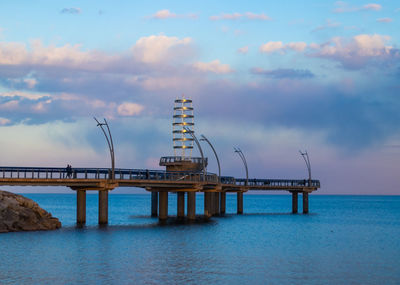 Pier over sea against sky during sunset