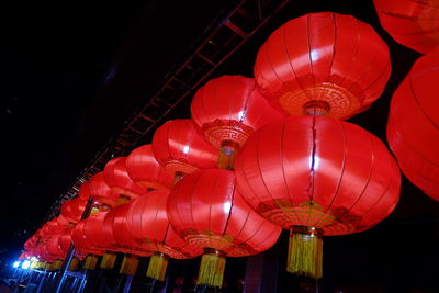 Low angle view of illuminated lanterns hanging at night