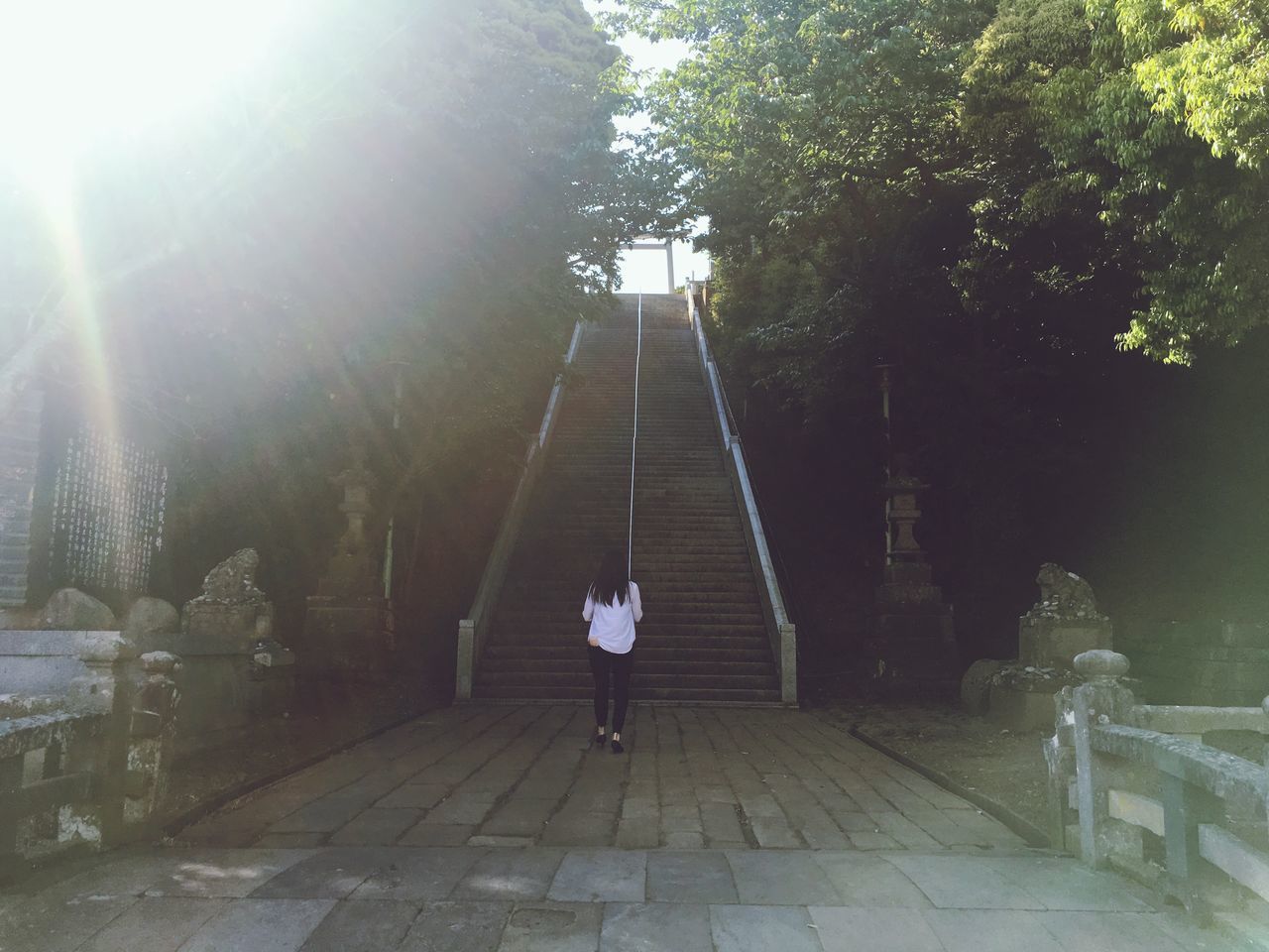 REAR VIEW OF WOMAN WALKING ON WALKWAY