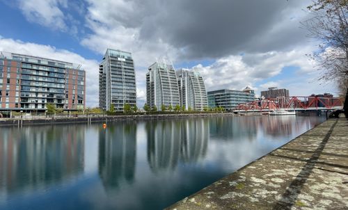 Reflection of buildings in river against sky