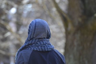 Rear view of person wearing scarf in forest