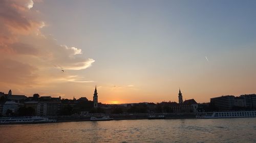 View of buildings at waterfront during sunset