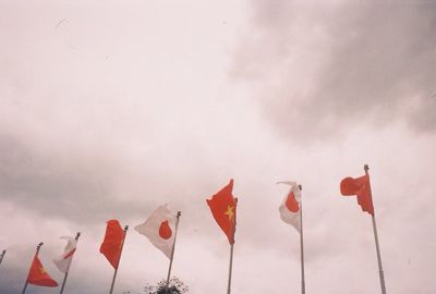 Low angle view of flags against sky