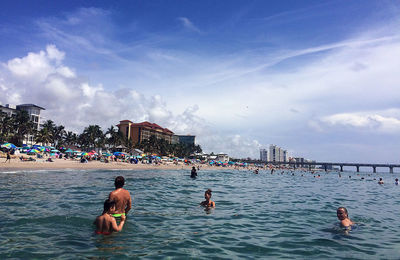 People enjoying in sea against sky