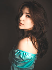 Portrait of a beautiful young woman over black background