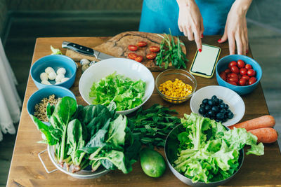 Close-up of a kitchen table with herbs and vegetables. vegetarian salad ingredients. 