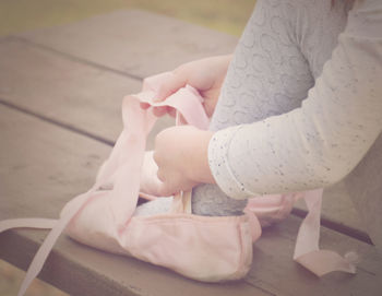 Close-up of girl tying ballet shoes