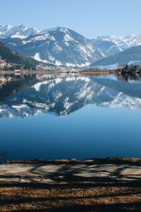 Scenic view of alpine lake and snowcapped mountains against sky