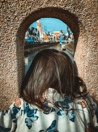 Rear view of woman against wall