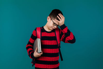 Young woman standing against blue background