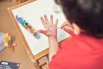 Children playing in an inner courtyard and painting with water paints