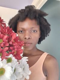 Close-up portrait of woman with red flower