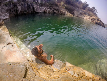 Man surfing on rock in sea