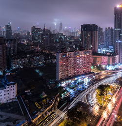 High angle view of illuminated cityscape against sky at night