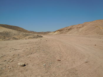 Scenic view of desert against clear blue sky