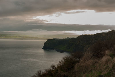 View of calm beach against clouds