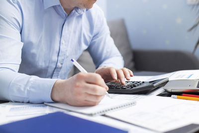 Midsection of businessman working at office