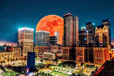 Illuminated cityscape against clear sky at night