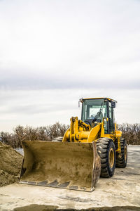 View of yellow construction site on field against sky