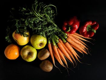 Fruits and tomatoes against black background