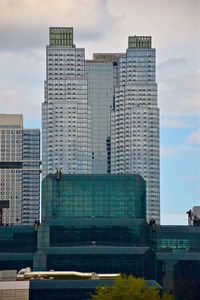 Modern cityscape by sea against sky