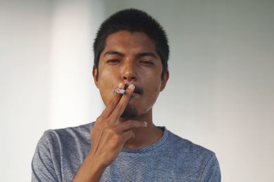 Portrait of young man smoking cigarette