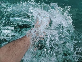 High angle view of hand splashing water in sea