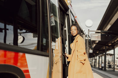 Young woman entering bus
