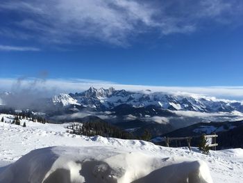 Scenic view of snowcapped mountains against blue sky