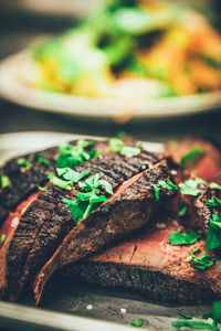 Close-up of meat garnished with cilantro on plate