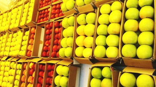 Full frame shot of apples in boxes on table at market