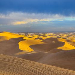 Scenic view of desert against sky during sunset