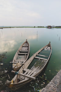 Abandoned boat moored in lake against sky