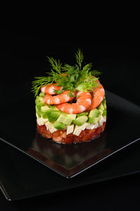 Close-up of sushi in plate on table against black background