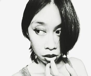 Close-up portrait of young woman against white background