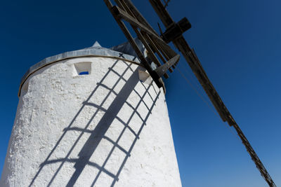 Low angle view of windmill against clear blue sky