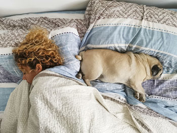 Rear view of woman with dog on bed