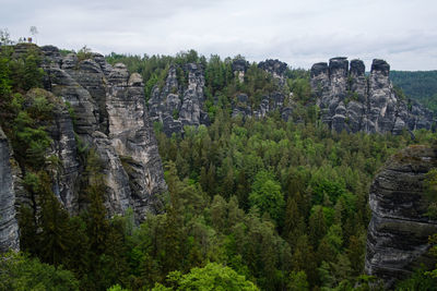 Scenic view of rocks and trees against sky