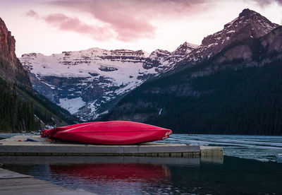 Scenic view of lake by snowcapped mountains against sky