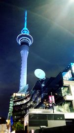 Low angle view of illuminated tower against sky in city