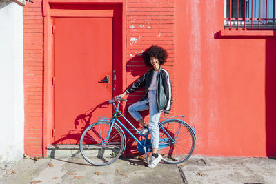 Bicycle parked against red wall