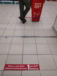 Low section of person with text on tiled floor