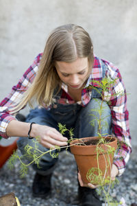 Young woman planting plant, stockholm, sweden