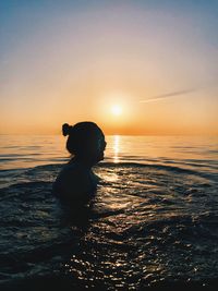Silhouette man on beach against sky during sunset