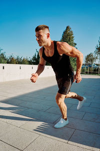 Portrait of young man exercising on street