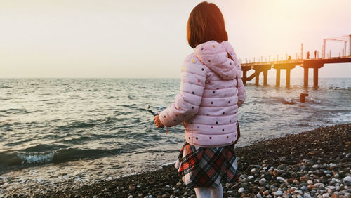 Rear view of woman looking at sea against sky
